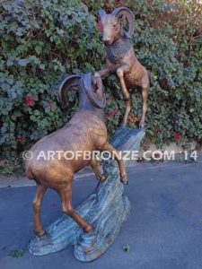 Clash of the Titans special edition, monumental outdoor rams clashing on bronze rock ledge