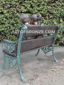 Friendship bronze sculpture of young girl and boy sitting on bench looking at book