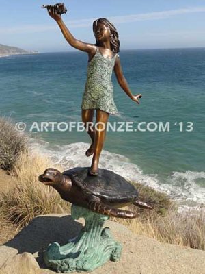 A Treasured Day Bronze sculpture of whimsical girl on turtle playing with seashell