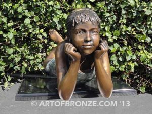 Day Dreaming bronze statue of relaxing girl lying down on stomach