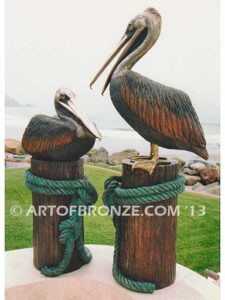 Taking a Break bronze statue of playful pelicans on bronze pilings