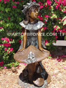 Wonderland bronze sculpture of giant mushroom and standing girl with frog