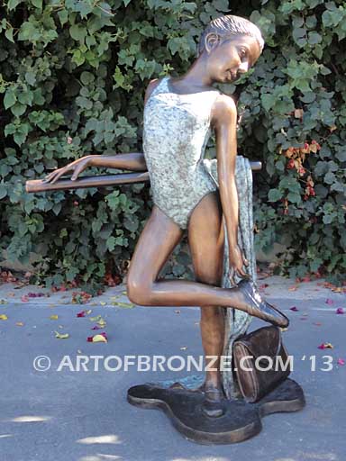 Rehearsal bronze sculpture featuring young ballerina practicing on rail