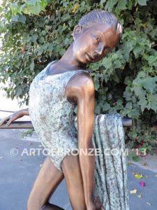 Rehearsal bronze sculpture featuring young ballerina practicing on rail