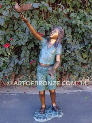 Faith bronze sculpture of young standing girl with doves in her hands