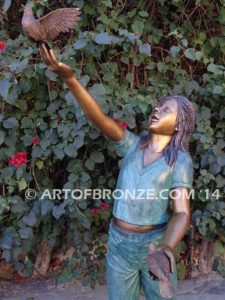 Faith bronze sculpture of young standing girl with doves in her hands
