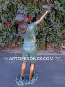 Faith bronze sculpture of young standing girl with doves in her hands
