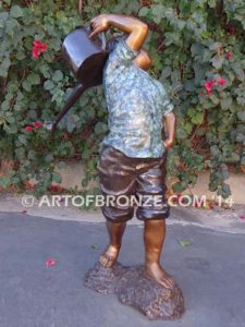 Strolling Along bronze sculpture of boy helping in garden watering flowers