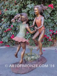 Dance Around bronze sculpture of two girls holding hands and dancing