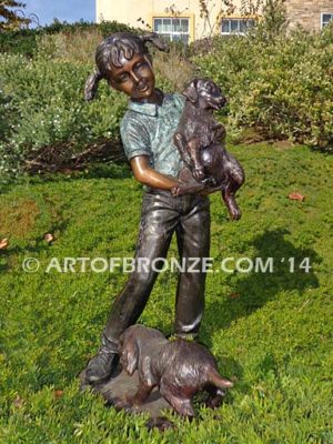 Play with Me Too bronze sculpture of girl holding dog with other dog chewing on her shoelace