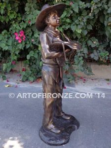 Saddle Up bronze sculpture of cowboy mounting saddle