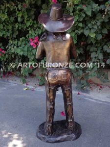 Saddle Up bronze sculpture of cowboy mounting saddle