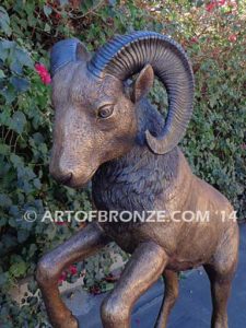 Clash of the Titans special edition, monumental outdoor rams clashing on bronze rock ledge