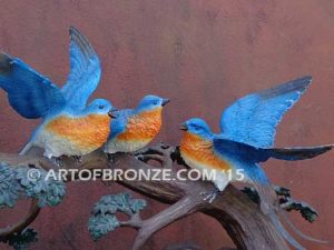 Bronze sculpture of five finches playing together on branch