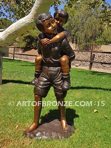 Piggyback bronze statue of boy carrying young girl on his back