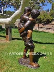 Piggyback bronze statue of boy carrying young girl on his back