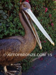 Pelican Perch bronze statue of playful pelican on bronze piling