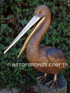 Pelican Perch bronze statue of playful pelican on bronze piling