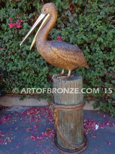 Pelican Perch bronze statue of playful pelican on bronze piling