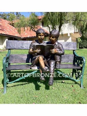 Friendship bronze sculpture of young girl and boy sitting on bench looking at book