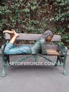 Best in Class bronze sculpture of young girl resting on bench reading her favorite novel