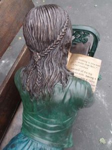 Best in Class bronze sculpture of young girl resting on bench reading her favorite novel