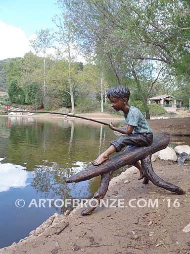 Fish n Day bronze statue of young boy sitting on log fishing