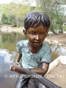 Fish n Day bronze sculpture of young boy sitting on log fishing