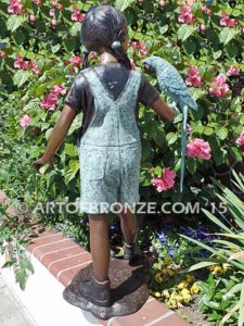 Pretty Bird bronze sculpture of girl in overall shorts with exotic bird on arm