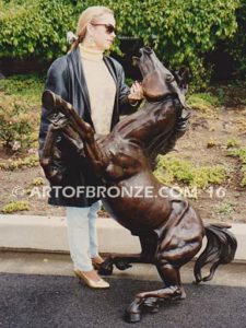 Reared Stallion outdoor life-size monumental equestrian horse sculptures with woman standing next to
