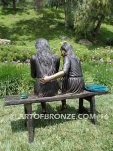 Big Sister back view bronze statue of two girls sitting on bench drawing
