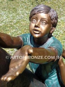 Big Rescue closeup A Bronze statue of boy and girl rescuing with cat in tree