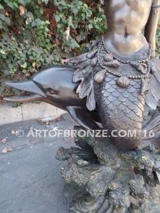 Bronze sculpture of mermaid blowing conch shell pond, pool or aquatic display