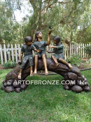 Butterfly Enchantment bronze sculpture of three kids sitting on log with butterfly net