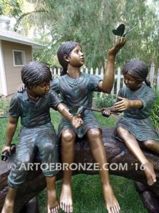 Butterfly Enchantment closeup B bronze sculpture of three kids sitting on log with butterfly net