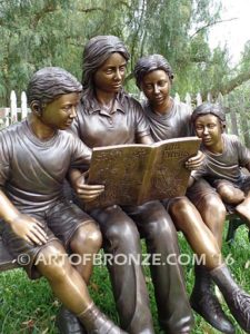 Making a Difference bronze sculpture of four children sitting on bench reading a book