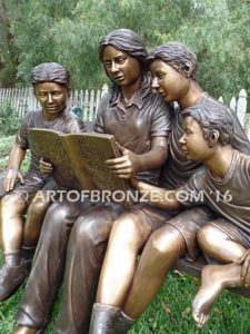 Making a Difference bronze sculpture of four children sitting on bench reading a book