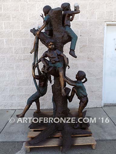 Bronze statue of five kids climbing in a tree