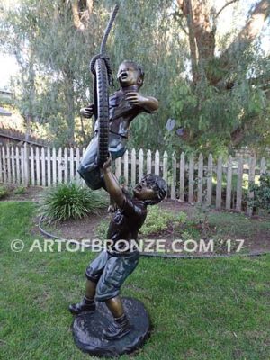 tire swing sculpture two boys playing on swing