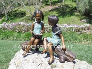 Favorite Teacher bronze statue of older girl reading book to younger boy