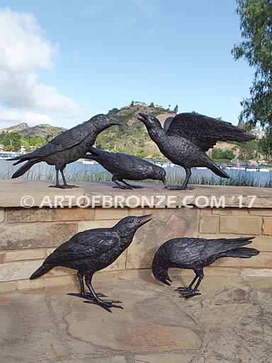 Raven bronze sculpture of ravens playing bench at lake