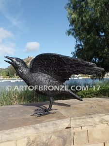 Raven bronze sculpture of ravens playing bench at lake