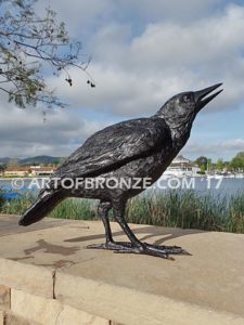 Raven bronze sculpture of ravens playing bench at lake