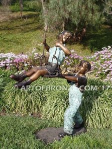Push Me Higher bronze sculpture for park or playground of boy pushing girl on swing