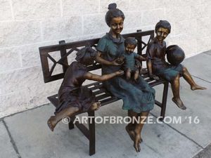 Special Day Together bronze sculpture of mother sitting on bench playing with her daughter, baby and soccer son