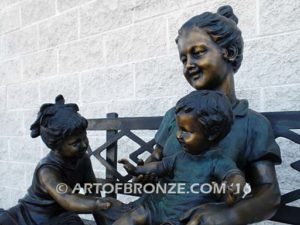 Special Day Together bronze sculpture of mother sitting on bench playing with her daughter, baby and soccer son