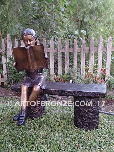 Little learner sculpture of sitting girl reading book on bench