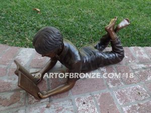 Best in His Class Sm side view bronze statue of boy lying down reading book