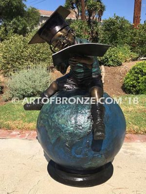 Global Scholar bronze sculpture of boy sitting on globe wearing graduation cap and reading book