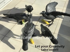 Raven bronze sculpture of ravens playing on patio eating corn